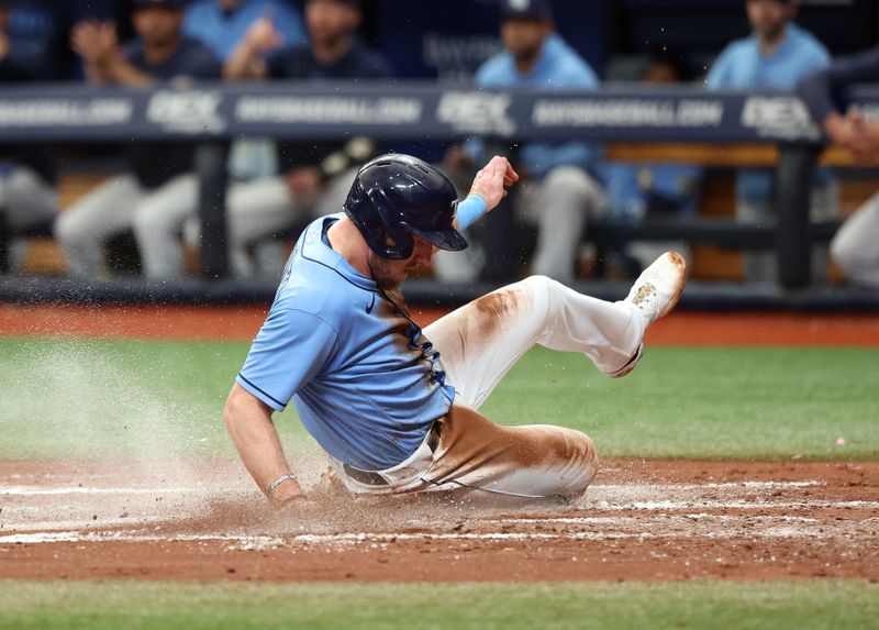 May 28, 2023; St. Petersburg, Florida, USA; Tampa Bay Rays right fielder Luke Raley (55) slides home to score a run against the Los Angeles Dodgers during the third inning at Tropicana Field. Mandatory Credit: Kim Klement-USA TODAY Sports