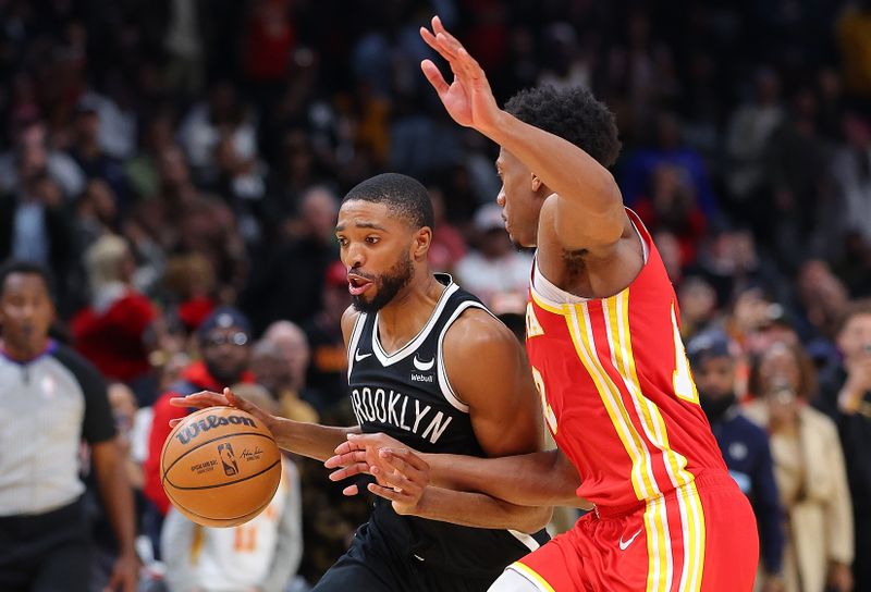 ATLANTA, GEORGIA - DECEMBER 06:  Mikal Bridges #1 of the Brooklyn Nets drives against De'Andre Hunter #12 of the Atlanta Hawks prior to shooting what ends up being the game-winning basket during the fourth quarter at State Farm Arena on December 06, 2023 in Atlanta, Georgia.  NOTE TO USER: User expressly acknowledges and agrees that, by downloading and/or using this photograph, user is consenting to the terms and conditions of the Getty Images License Agreement.  (Photo by Kevin C. Cox/Getty Images)