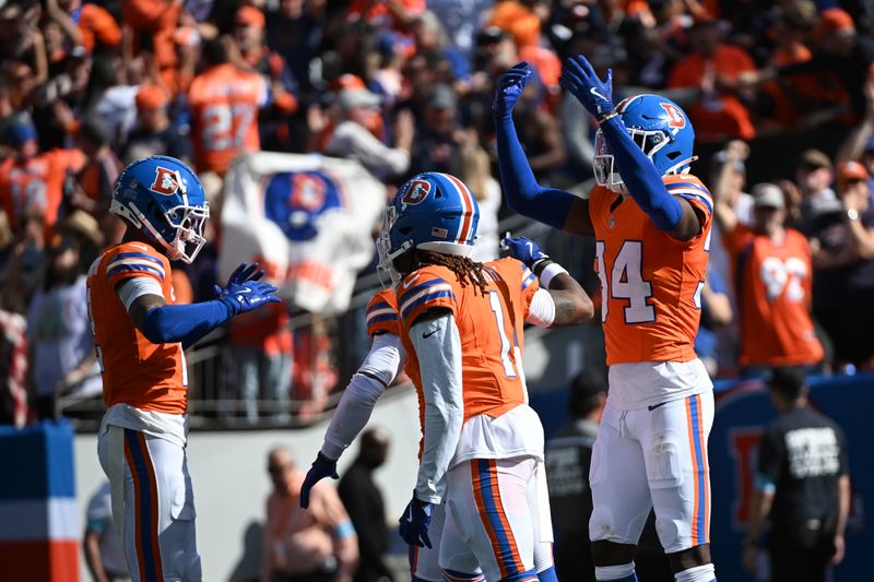 Denver Broncos cornerback Pat Surtain II, left, celebrates his 100-yard interception for a touchdown during the first half of an NFL football game against the Las Vegas Raiders, Sunday, Oct. 6, 2024, in Denver. (AP Photo/Geneva Heffernan)