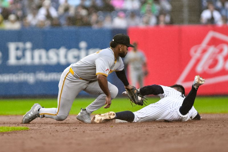 Sep 29, 2024; Bronx, New York, USA; Pittsburgh Pirates shortstop Liover Peguero (31) tags out New York Yankees shortstop Anthony Volpe (11) during a steal attempt at second base during the second inning at Yankee Stadium. Mandatory Credit: John Jones-Imagn Images