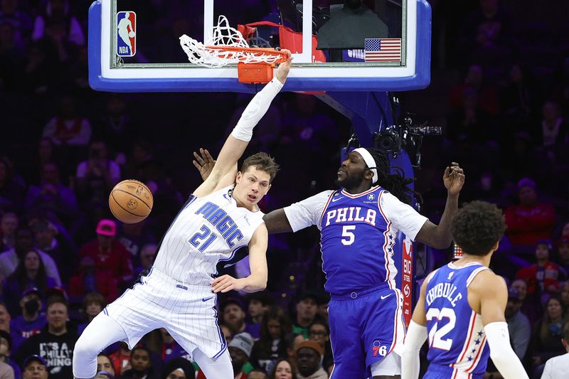 PHILADELPHIA, PENNSYLVANIA - FEBRUARY 01: Moritz Wagner #21 of the Orlando Magic dunks past Montrezl Harrell #5 of the Philadelphia 76ers during the second quarter at Wells Fargo Center on February 01, 2023 in Philadelphia, Pennsylvania. NOTE TO USER: User expressly acknowledges and agrees that, by downloading and or using this photograph, User is consenting to the terms and conditions of the Getty Images License Agreement. (Photo by Tim Nwachukwu/Getty Images)