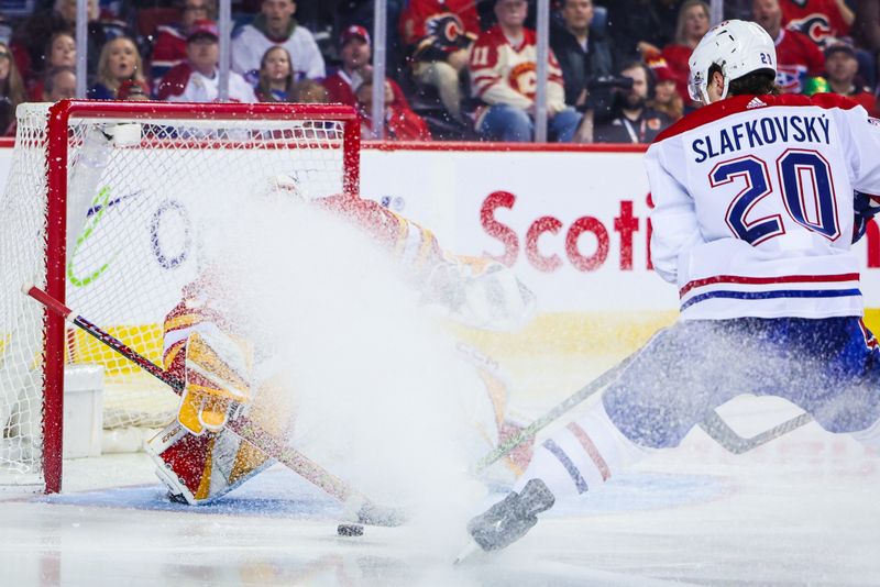 Mar 16, 2024; Calgary, Alberta, CAN; Calgary Flames goaltender Dustin Wolf (32) makes a save against Montreal Canadiens left wing Juraj Slafkovsky (20) during the third period at Scotiabank Saddledome. Mandatory Credit: Sergei Belski-USA TODAY Sports