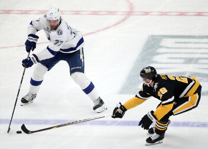 Nov 19, 2024; Pittsburgh, Pennsylvania, USA; Tampa Bay Lightning defenseman Victor Hedman (77) moves the puck against Pittsburgh Penguins defenseman Marcus Pettersson (28) during the second period at PPG Paints Arena. Mandatory Credit: Charles LeClaire-Imagn Images