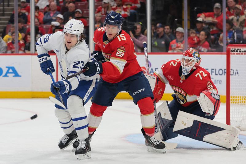 Dec 2, 2025; Sunrise, Florida, USA; Toronto Maple Leafs left wing Matthew Knies (23) attempts to deflect the puck as Florida Panthers center Anton Lundell (15) and goaltender Sergei Bobrovsky (72) defend during the second period at Amerant Bank Arena. Mandatory Credit: Sam Navarro-Imagn Images
