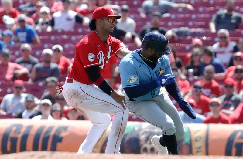 Apr 19, 2023; Cincinnati, Ohio, USA; Tampa Bay Rays first baseman Yandy Diaz right) is tagged out to turn a double play against Cincinnati Reds shortstop Jose Barrero (left) during the eighth inning at Great American Ball Park. Mandatory Credit: David Kohl-USA TODAY Sports