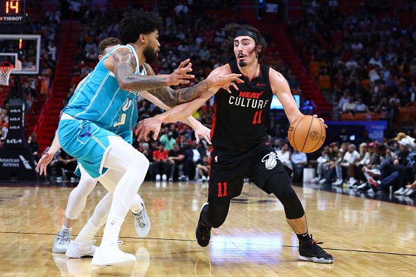 MIAMI, FLORIDA - DECEMBER 13: Jaime Jaquez Jr. #11 of the Miami Heat dribbles the ball against Nick Richards #4 of the Charlotte Hornets during the second quarter at Kaseya Center on December 13, 2023 in Miami, Florida. NOTE TO USER: User expressly acknowledges and agrees that, by downloading and or using this photograph, User is consenting to the terms and conditions of the Getty Images License Agreement. (Photo by Megan Briggs/Getty Images)