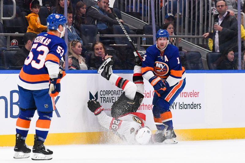 Oct 26, 2023; Elmont, New York, USA; New York Islanders right wing Cal Clutterbuck (15) checks Ottawa Senators defenseman Erik Brannstrom (26) into the boards during the second period at UBS Arena. Mandatory Credit: Dennis Schneidler-USA TODAY Sports