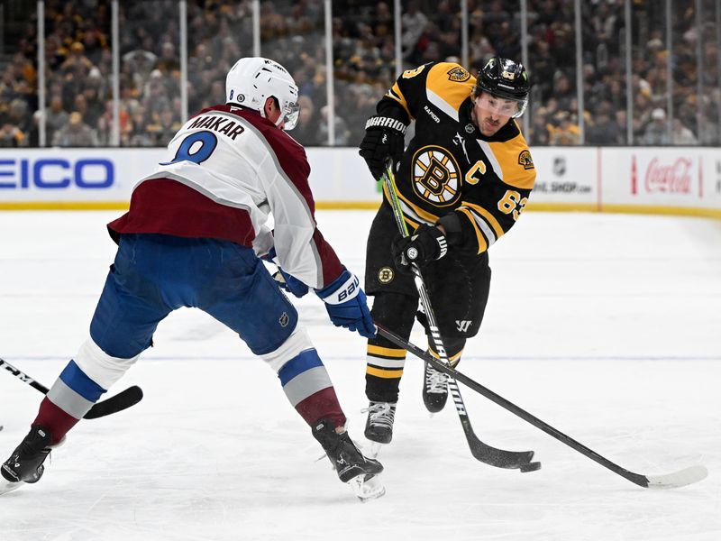Jan 25, 2025; Boston, Massachusetts, USA; Boston Bruins left wing Brad Marchand (63) passes the puck against Colorado Avalanche defenseman Cale Makar (8) during the first period at the TD Garden. Mandatory Credit: Brian Fluharty-Imagn Images
