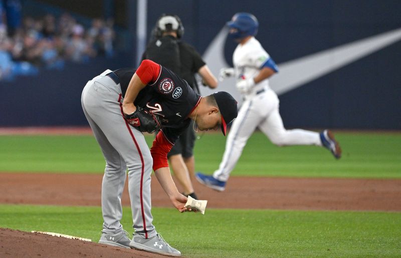 Aug 29, 2023; Toronto, Ontario, CAN;  Washington Nationals pitcher MacKenzie Gore (1) prepares for his next pitch as Toronto Blue Jays second baseman Davis Schneider (36) rounds the bases after hitting a solo home run in the third inning at Rogers Centre. Mandatory Credit: Dan Hamilton-USA TODAY Sports