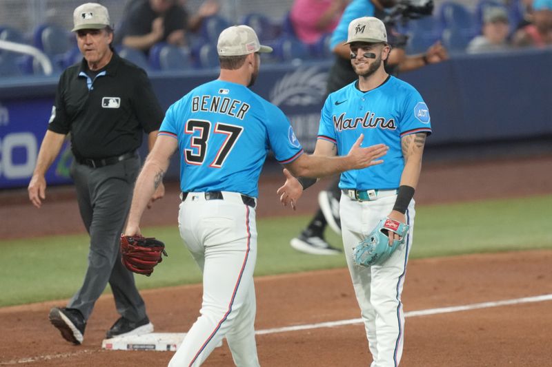 May 18, 2025; Miami, Florida, USA;  Miami Marlins pitcher Anthony Bender (37) shakes hands with third baseman Connor Norby (1) after catching the last out against the Tampa Bay Rays at loanDepot Park. Mandatory Credit: Jim Rassol-Imagn Images