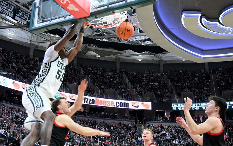 Dec 29, 2025; East Lansing, Michigan, USA;  Michigan State Spartans forward Coen Carr (55) dunks on a slash from the side against the Cornell Big Red during the second half at Jack Breslin Student Events Center. Mandatory Credit: Dale Young-Imagn Images