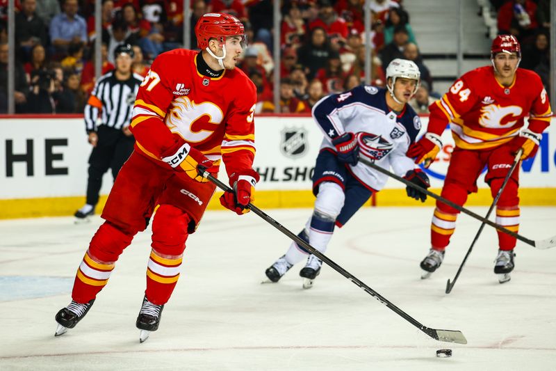 Nov 5, 2025; Calgary, Alberta, CAN; Calgary Flames defenseman Yan Kuznetsov (37) skates with the puck against the Columbus Blue Jackets during the first period at Scotiabank Saddledome. Mandatory Credit: Sergei Belski-Imagn Images