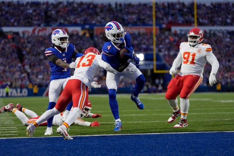 Buffalo Bills running back James Cook (4) scores past Kansas City Chiefs cornerback Nazeeh Johnson (13) and defensive tackle Derrick Nnadi (91) during the first half of an NFL football game Sunday, Nov. 17, 2024, in Orchard Park, N.Y. (AP Photo/Julia Demaree Nikhinson)