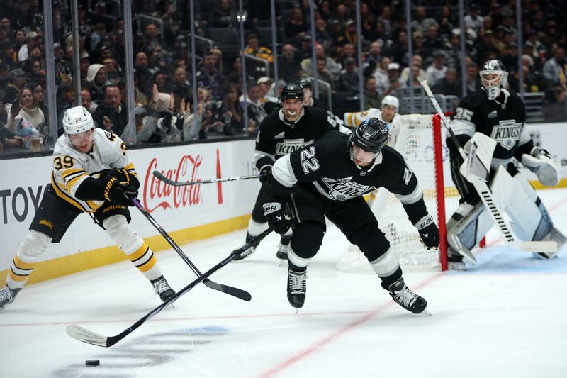 Nov 21, 2025; Los Angeles, California, USA;  Los Angeles Kings left wing Kevin Fiala (22) fights for the puck against Boston Bruins center Morgan Geekie (39) during the third period at Crypto.com Arena. Mandatory Credit: Kiyoshi Mio-Imagn Images