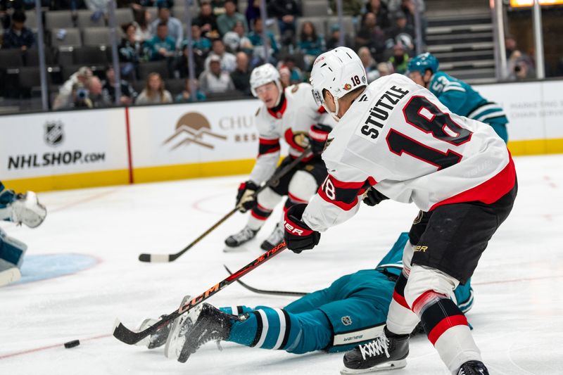 Nov 27, 2024; San Jose, California, USA; Ottawa Senators center Tim Stützle (18) passes the puck in front of the net against the San Jose Sharks during the first period at SAP Center at San Jose. Mandatory Credit: Neville E. Guard-Imagn Images