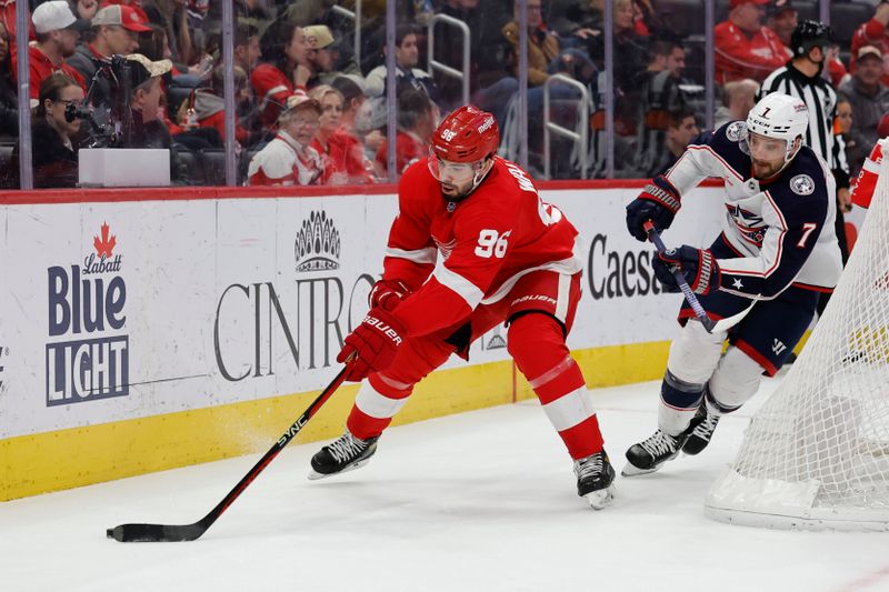 Nov 11, 2023; Detroit, Michigan, USA;  Detroit Red Wings defenseman Jake Walman (96) skates with the puck against Columbus Blue Jackets center Sean Kuraly (7) in the first period at Little Caesars Arena. Mandatory Credit: Rick Osentoski-USA TODAY Sports