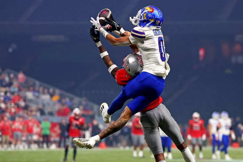 Dec 26, 2023; Phoenix, AZ, USA; Kansas Jayhawks wide receiver Quentin Skinner (0) makes a catch against UNLV Rebels defensive back Ricky Johnson (33) during the second half in the Guaranteed Rate Bowl at Chase Field. Mandatory Credit: Mark J. Rebilas-USA TODAY Sports