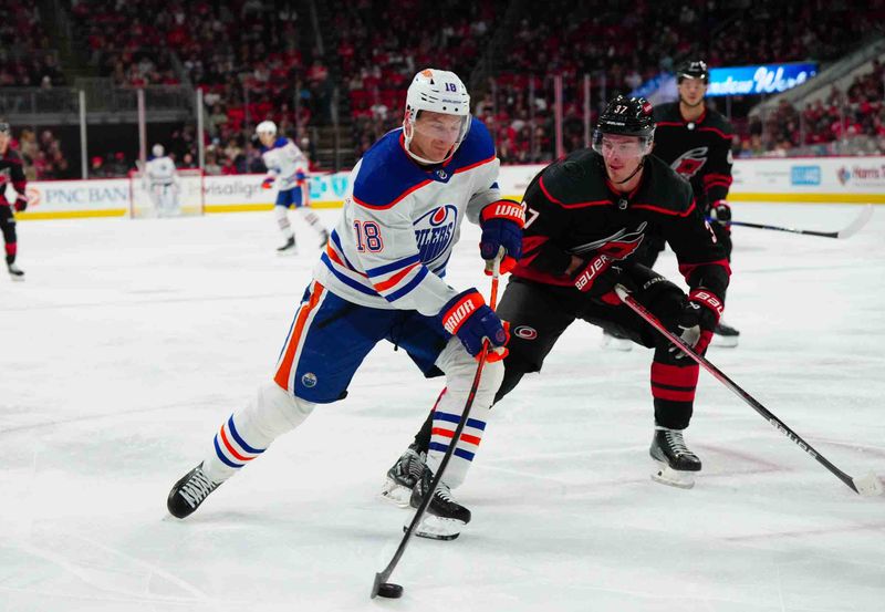 Nov 22, 2023; Raleigh, North Carolina, USA; Edmonton Oilers left wing Zach Hyman (18) gets ready to take a shot against Carolina Hurricanes right wing Andrei Svechnikov (37) during the second period at PNC Arena. Mandatory Credit: James Guillory-USA TODAY Sports