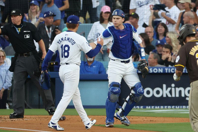 Oct 11, 2024; Los Angeles, California, USA; Los Angeles Dodgers catcher Will Smith (16) greets pitcher Yoshinobu Yamamoto (18) in the third inning against the San Diego Padres during game five of the NLDS for the 2024 MLB Playoffs at Dodger Stadium. Mandatory Credit: Kiyoshi Mio-Imagn Images