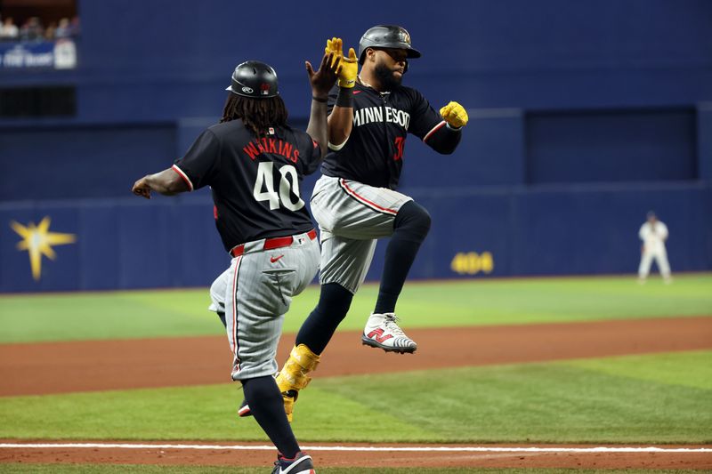 Sep 4, 2024; St. Petersburg, Florida, USA; Minnesota Twins first base Carlos Santana (30) is congratulated by  third base coach/outfield coach Tommy Watkins (40) after he hit a 2-run home against the Tampa Bay Rays during the seventh inning  at Tropicana Field. Mandatory Credit: Kim Klement Neitzel-Imagn Images