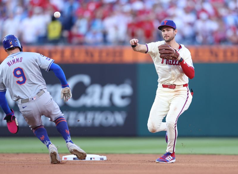 Oct 5, 2024; Philadelphia, PA, USA; Philadelphia Phillies shortstop Trea Turner (7) turns a double play against New York Mets outfielder Brandon Nimmo (9) in the fourth inning in game one of the NLDS for the 2024 MLB Playoffs at Citizens Bank Park. Mandatory Credit: Bill Streicher-Imagn Images