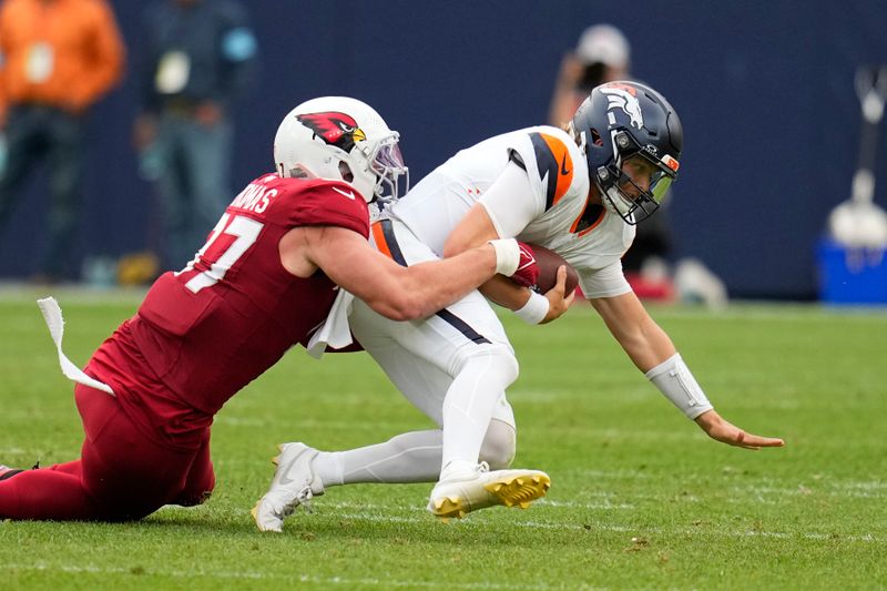 Denver Broncos quarterback Zach Wilson, right, gets sacked by Arizona Cardinals linebacker Cameron Thomas, left, during the second half of a preseason NFL football game Sunday, Aug. 25, 2024, in Denver. (AP Photo/Jack Dempsey)