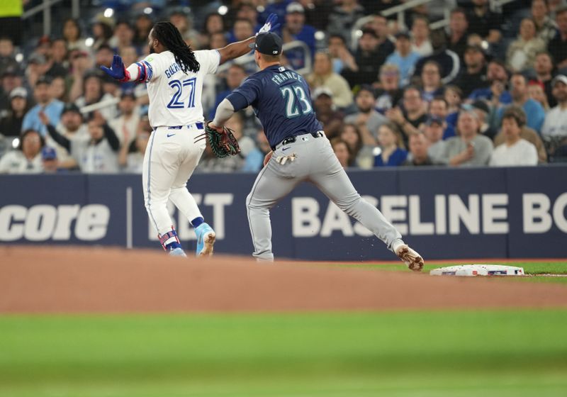 Apr 9, 2024; Toronto, Ontario, CAN; Toronto Blue Jays first base Vladimir Guerrero Jr. (27) signals safe at first base on a throwing error against the Seattle Mariners during the first inning at Rogers Centre. Mandatory Credit: Nick Turchiaro-USA TODAY Sports