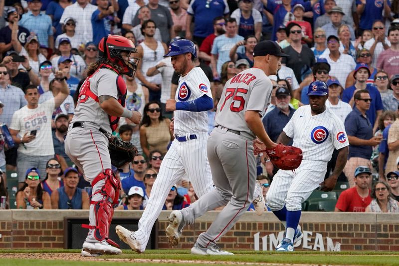 Jul 15, 2023; Chicago, Illinois, USA; Chicago Cubs center fielder Cody Bellinger (24) scores as Boston Red Sox catcher Connor Wong (12) stands nearby during the seventh inning at Wrigley Field. Mandatory Credit: David Banks-USA TODAY Sports