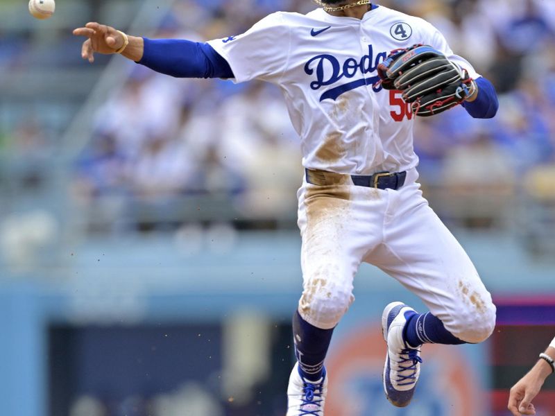 Jun 2, 2024; Los Angeles, California, USA;  Los Angeles Dodgers shortstop Mookie Betts (50) throws to first after a getting Colorado Rockies outfielder Hunter Goodman (15) out at second in the fifth inning at Dodger Stadium. Mandatory Credit: Jayne Kamin-Oncea-USA TODAY Sports