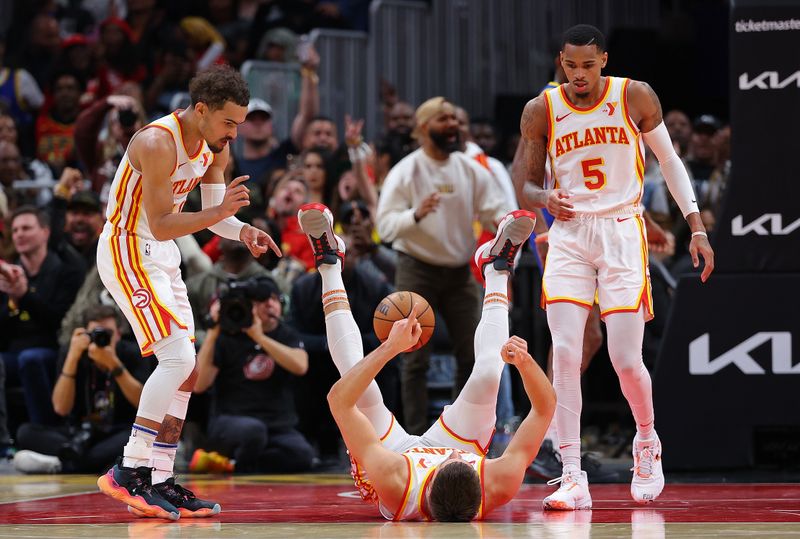 ATLANTA, GEORGIA - FEBRUARY 03:  Bogdan Bogdanovic #13 of the Atlanta Hawks reacts with Trae Young #11 and Dejounte Murray #5 of the Atlanta Hawks after drawing a foul on a basket against the Golden State Warriors during the fourth quarter at State Farm Arena on February 03, 2024 in Atlanta, Georgia.  NOTE TO USER: User expressly acknowledges and agrees that, by downloading and/or using this photograph, user is consenting to the terms and conditions of the Getty Images License Agreement.  (Photo by Kevin C. Cox/Getty Images)