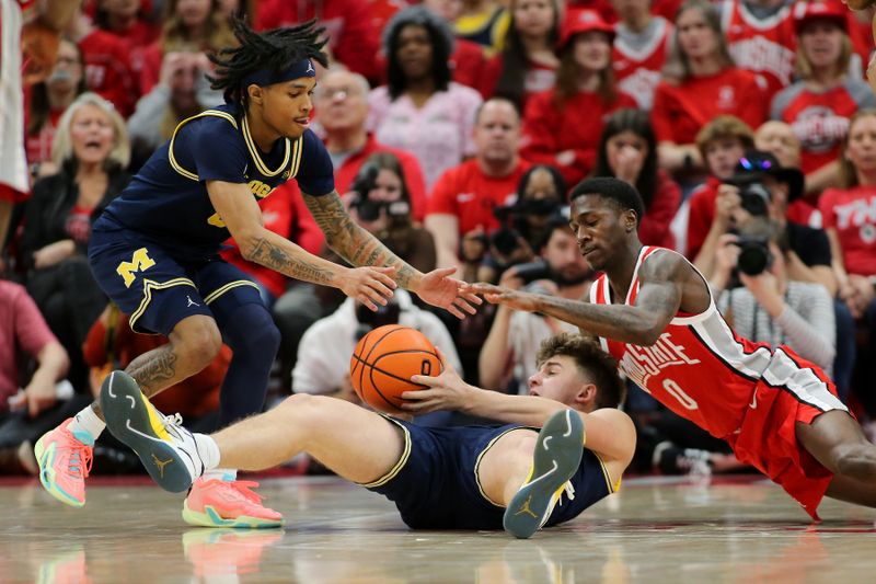 Mar 3, 2024; Columbus, Ohio, USA;  Ohio State Buckeyes guard Scotty Middleton (right) dives for the loose ball as Michigan Wolverines forward Will Tschetter (42) holds onto the ball during the second half at Value City Arena. Mandatory Credit: Joseph Maiorana-USA TODAY Sports