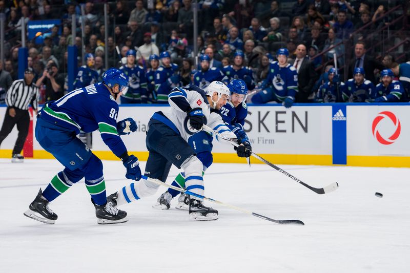 Mar 9, 2024; Vancouver, British Columbia, CAN; Vancouver Canucks forward Vasily Podkolzin (92) and forward Elias Lindholm (23) checks Winnipeg Jets forward Nino Niederreiter (62) in the third period at Rogers Arena. Canucks won 5-0. Mandatory Credit: Bob Frid-USA TODAY Sports