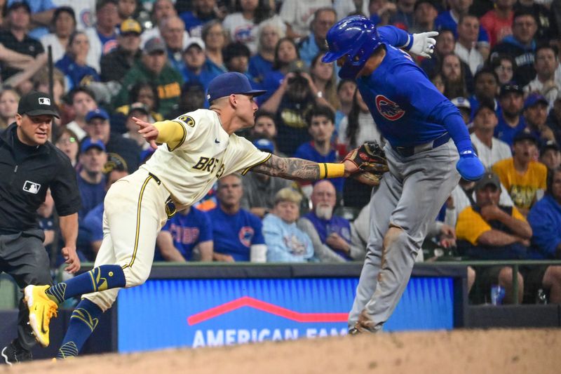 May 29, 2024; Milwaukee, Wisconsin, USA;  Milwaukee Brewers third baseman Joey Ortiz (3) tags out Chicago Cubs right fielder Seiya Suzuki (27) trying to advance to third base in the fifth inning at American Family Field. Mandatory Credit: Benny Sieu-USA TODAY Sports