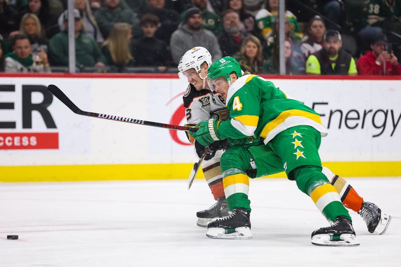 Jan 27, 2024; Saint Paul, Minnesota, USA; Minnesota Wild defenseman Jon Merrill (4) and Anaheim Ducks right wing Jakob Silfverberg (33) compete for the puck during the first period at Xcel Energy Center. Mandatory Credit: Matt Krohn-USA TODAY Sports