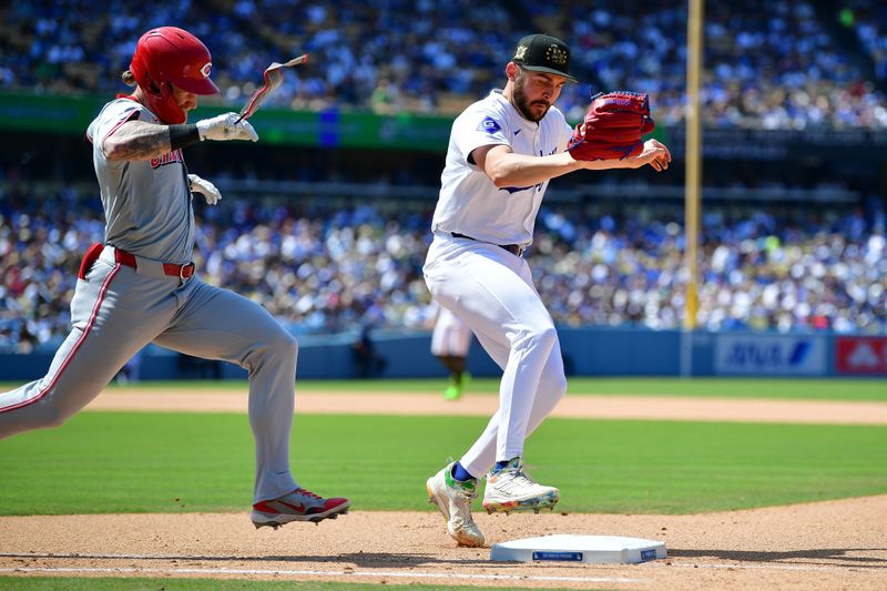 May 19, 2024; Los Angeles, California, USA; Los Angeles Dodgers pitcher Alex Vesia (51) tags first for the out against Cincinnati Reds right fielder Jake Fraley (27) during the eighth inning at Dodger Stadium. Mandatory Credit: Gary A. Vasquez-USA TODAY Sports