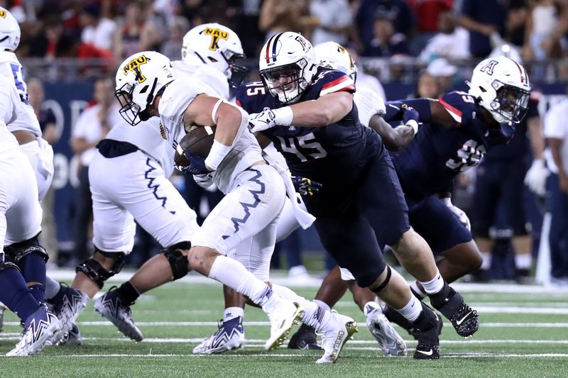 Sep 2, 2023; Tucson, Arizona, USA; Arizona Wildcats defensive lineman Bill Norton (45) tackles Northern Arizona Lumberjacks running back TJ McDaniel (1) during the second half at Arizona Stadium. Mandatory Credit: Zac BonDurant-USA TODAY Sports