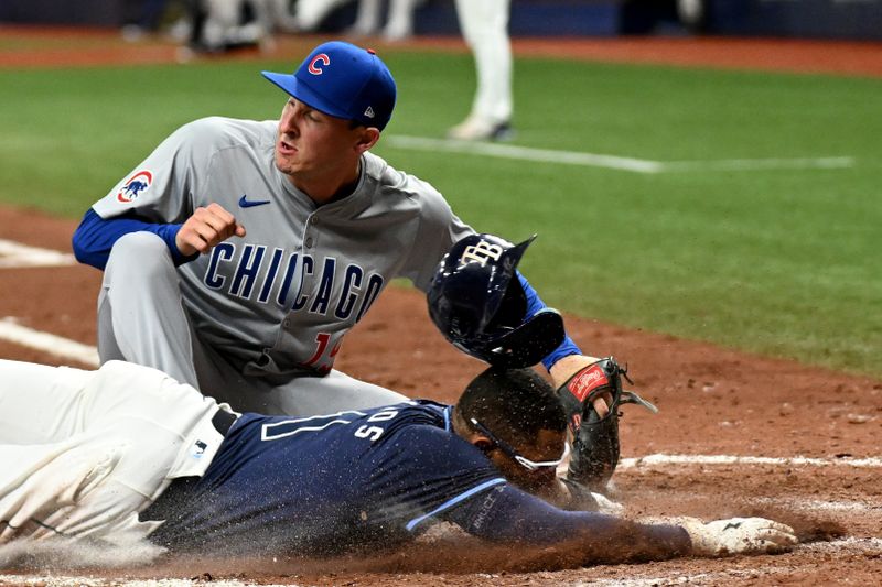 Jun 11, 2024; St. Petersburg, Florida, USA; Tampa Bay Rays second baseman Richie Palacios (1) slides past the tag of Chicago Cubs relief pitcher Hayden Wesneski (19) to score a run in the seventh inning at Tropicana Field. Mandatory Credit: Jonathan Dyer-USA TODAY Sports