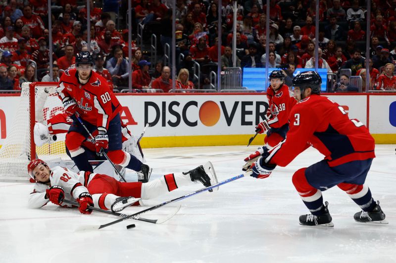 May 8, 2025; Washington, District of Columbia, USA; Carolina Hurricanes center Jesperi Kotkaniemi (82) dives to clear the puck from Washington Capitals defenseman Matt Roy (3) in the second period in game two of the second round of the 2025 Stanley Cup Playoffs at Capital One Arena. Mandatory Credit: Geoff Burke-Imagn Images