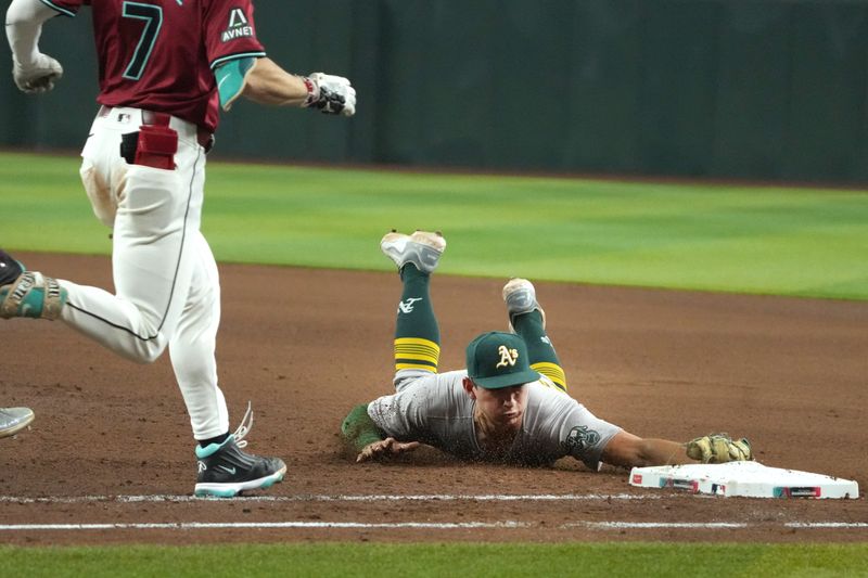 Jun 29, 2024; Phoenix, Arizona, USA; Oakland Athletics first base Tyler Soderstrom (21) makes the dive for the out against the Arizona Diamondbacks in the eighth inning at Chase Field. Mandatory Credit: Rick Scuteri-USA TODAY Sports