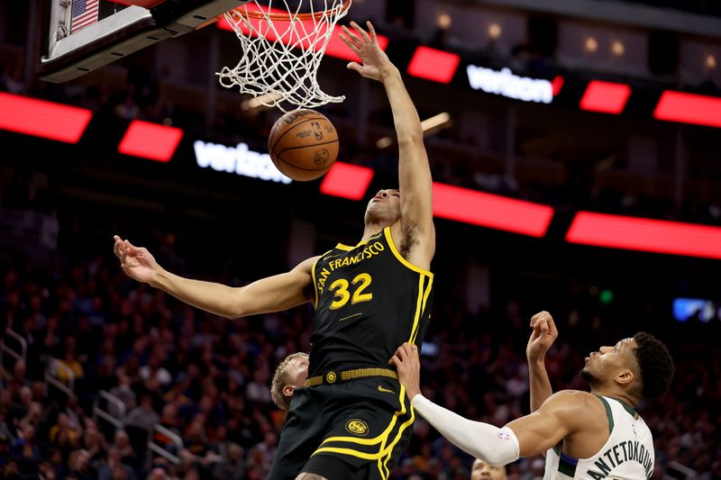 SAN FRANCISCO, CALIFORNIA - MARCH 06: Trayce Jackson-Davis #32 of the Golden State Warriors dunks the ball on Giannis Antetokounmpo #34 of the Milwaukee Bucks in the second half at Chase Center on March 06, 2024 in San Francisco, California. NOTE TO USER: User expressly acknowledges and agrees that, by downloading and or using this photograph, User is consenting to the terms and conditions of the Getty Images License Agreement.  (Photo by Ezra Shaw/Getty Images)