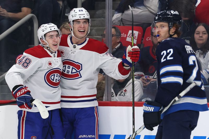 Dec 14, 2024; Winnipeg, Manitoba, CAN; Montreal Canadiens defenseman Lane Hutson (48) celebrates his first period with Montreal Canadiens left wing Juraj Slafkovsky (20) against the Winnipeg Jets at Canada Life Centre. Mandatory Credit: James Carey Lauder-Imagn Images