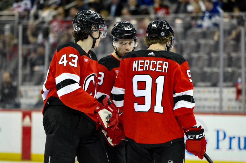 Apr 9, 2024; Newark, New Jersey, USA; New Jersey Devils defenseman Luke Hughes (43), left wing Jesper Bratt (63) and center Dawson Mercer (91) talk during a break in the action in the second period against the Toronto Maple Leafs at Prudential Center. Mandatory Credit: John Jones-USA TODAY Sports