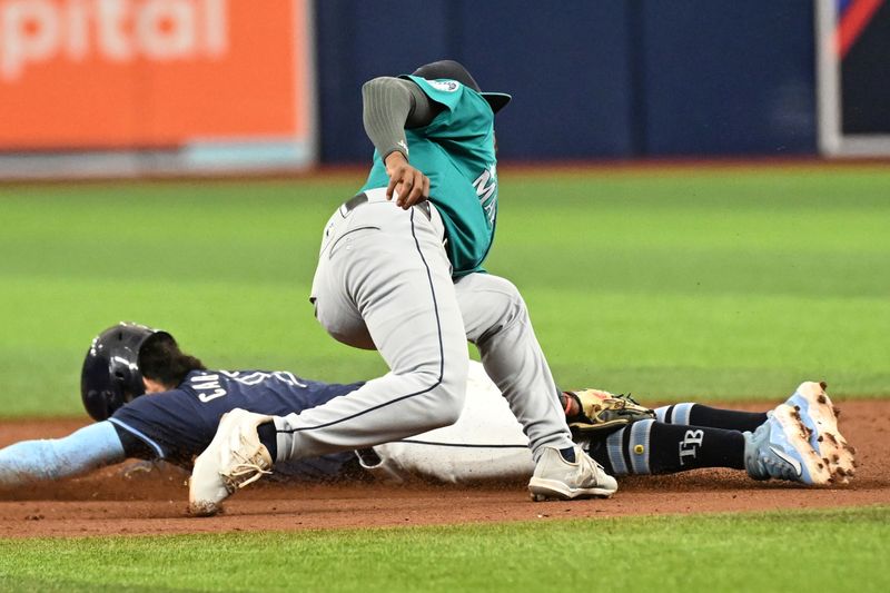 Jun 26, 2024; St. Petersburg, Florida, USA; Seattle Mariners second baseman Ryan Bliss (1) tags out Tampa Bay Rays short stop Jose Caballero (7) on a steal attempt in the fifth inning at Tropicana Field. Mandatory Credit: Jonathan Dyer-USA TODAY Sports