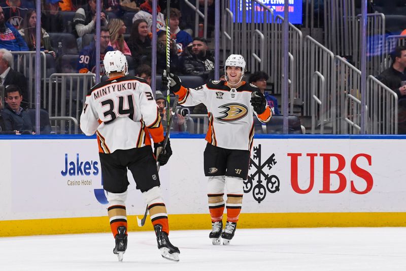 zDec 13, 2023; Elmont, New York, USA; Anaheim Ducks right wing Troy Terry (19) celebrates his goal with Anaheim Ducks defenseman Pavel Mintyukov (34) against the New York Islanders during the second period at UBS Arena. Mandatory Credit: Dennis Schneidler-USA TODAY Sports