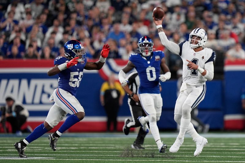 Dallas Cowboys quarterback Dak Prescott (4) passes against New York Giants linebacker Bobby Okereke (58) and New York Giants linebacker Brian Burns (0) during the second quarter of an NFL football game, Thursday, Sept. 26, 2024, in East Rutherford, N.J. (AP Photo/Bryan Woolston)