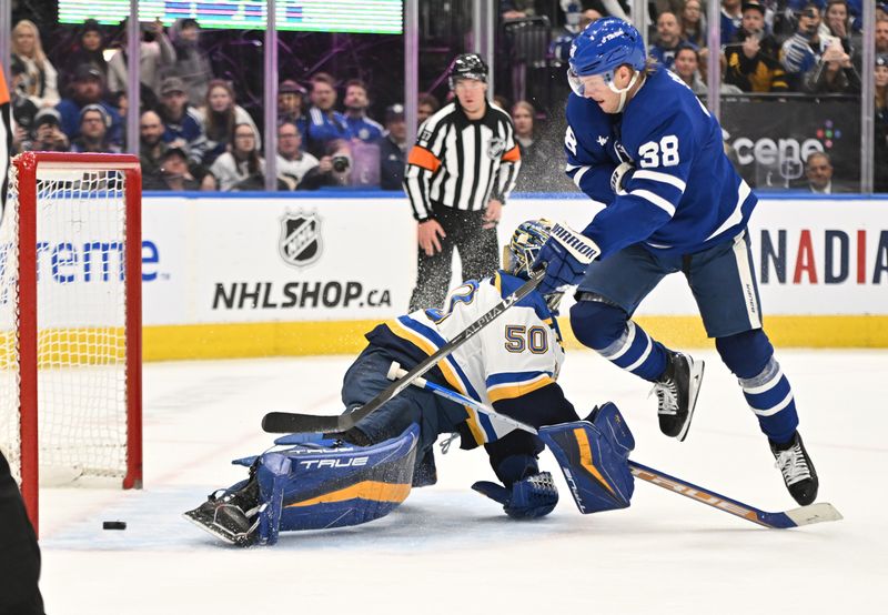 Jan 3, 2023; Toronto, Ontario, CAN; Toronto Maple Leafs defenseman Rasmus Sandin (38) shoots the puck wide past the skate of St. Louis Blues goalie Jordan Binnington (50) in overtime at Scotiabank Arena. Mandatory Credit: Dan Hamilton-USA TODAY Sports