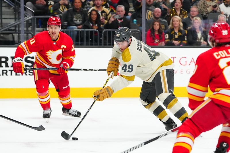 Jan 13, 2024; Las Vegas, Nevada, USA; Vegas Golden Knights center Ivan Barbashev (49) controls the puck between Calgary Flames center Mikael Backlund (11) and Calgary Flames center Blake Coleman (20) during the second period at T-Mobile Arena. Mandatory Credit: Stephen R. Sylvanie-USA TODAY Sports