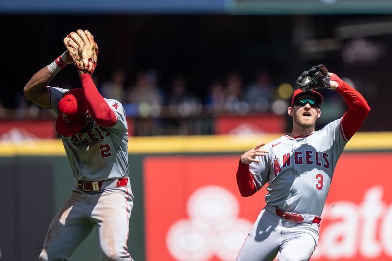 Jul 24, 2024; Seattle, Washington, USA;  Los Angeles Angels left fielder Taylor Ward (3) fields a fly ball for an out next to third baseman Luis Rengifo (2) during the second inning against the Seattle Mariners at T-Mobile Park. Mandatory Credit: Stephen Brashear-USA TODAY Sports