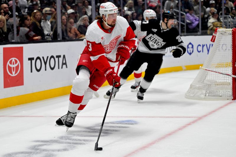 Nov 16, 2024; Los Angeles, California, USA; Detroit Red Wings defenseman Justin Holl (3) controls the puck away from Los Angeles Kings left wing Warren Foegele (37) in the second period at Crypto.com Arena. Mandatory Credit: Jayne Kamin-Oncea-Imagn Images