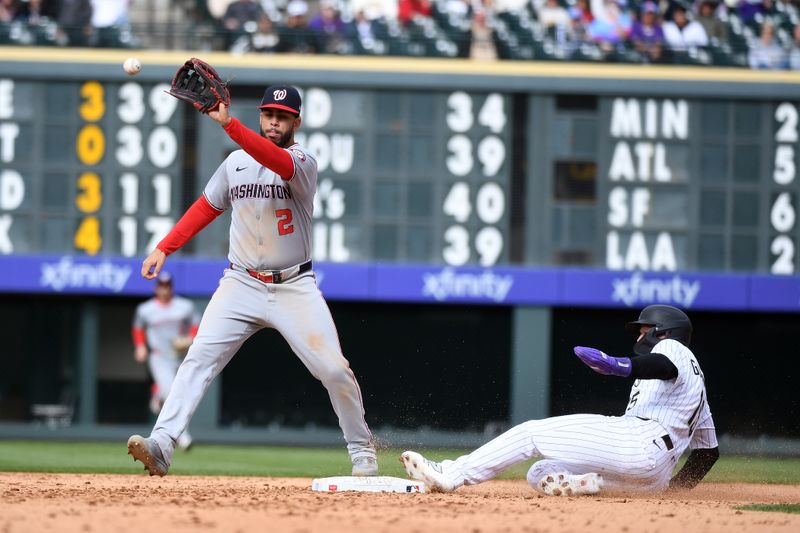 Apr 19, 2025; Denver, Colorado, USA; Colorado Rockies catcher Hunter Goodman (15) slides into second safely ahead of a play by Washington Nationals second base Luis García Jr. (2) during the seventh inning at Coors Field. Mandatory Credit: Christopher Hanewinckel-Imagn Images